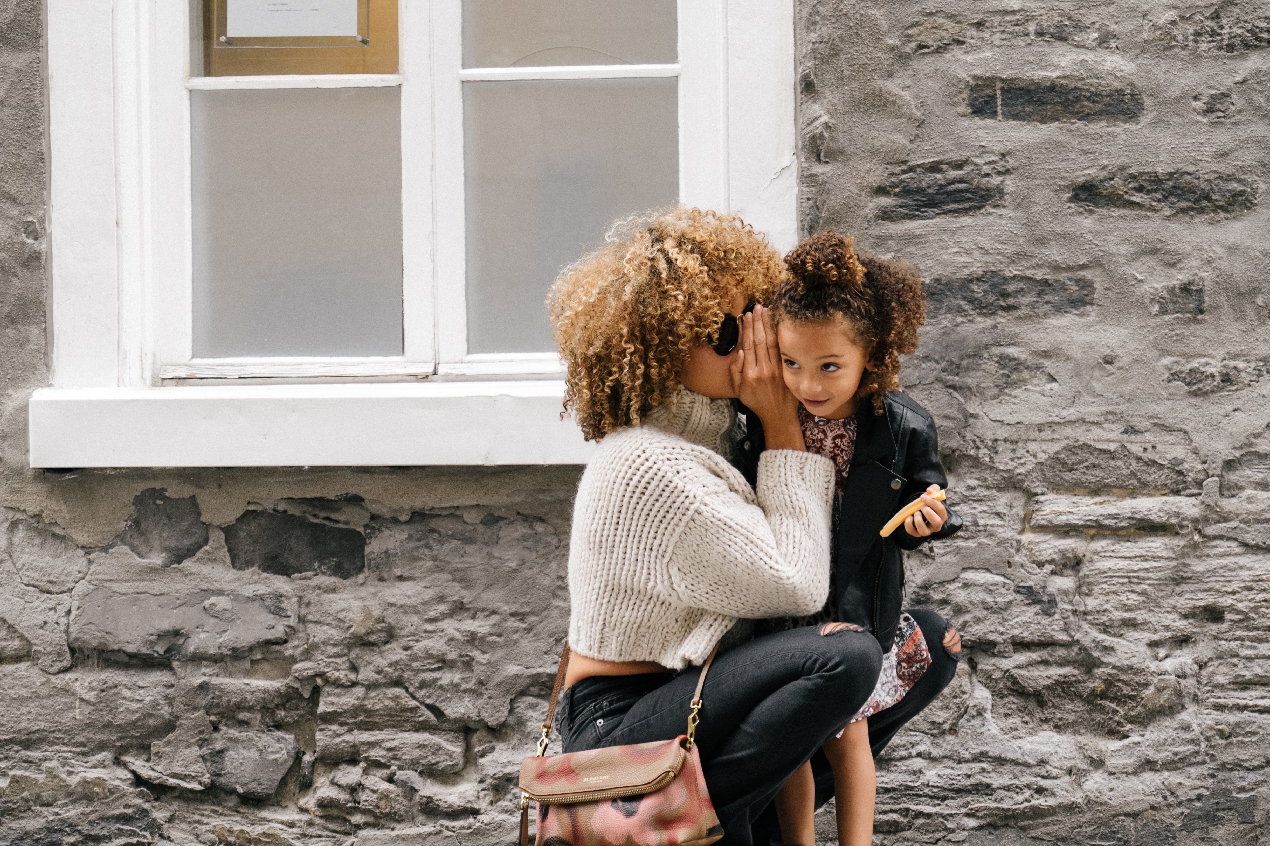 Woman whispering to kid